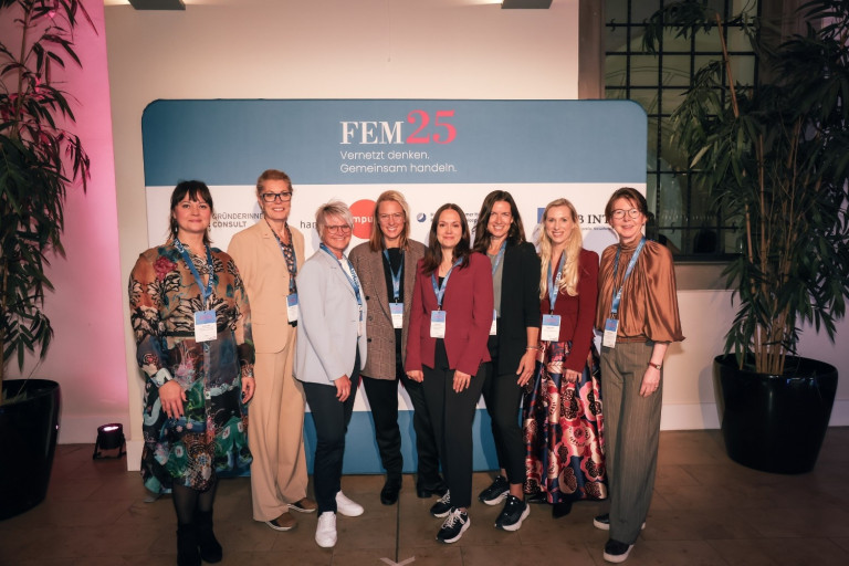 Gruppenfoto auf dem FEM25 Event mit Teilnehmerinnen vor dem FEM25 Banner
