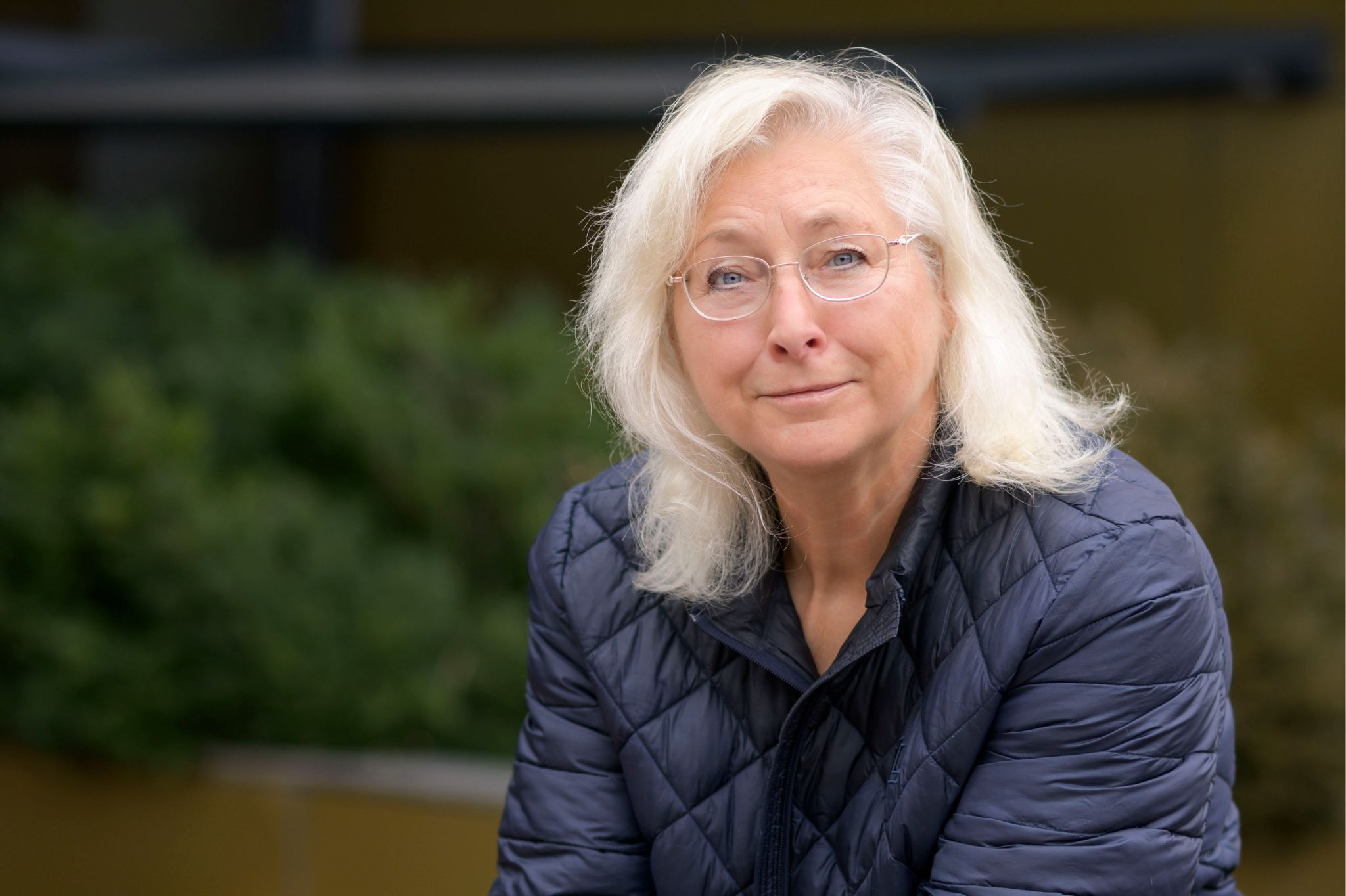 Beate Rossbach im Outdoor-Porträt mit blonder Frisur und blauer Steppjacke