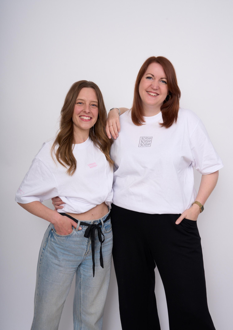 Zwei Frauen in weißen T-Shirts mit Aufdruck, Mode-Shooting vor weißem Hintergrund