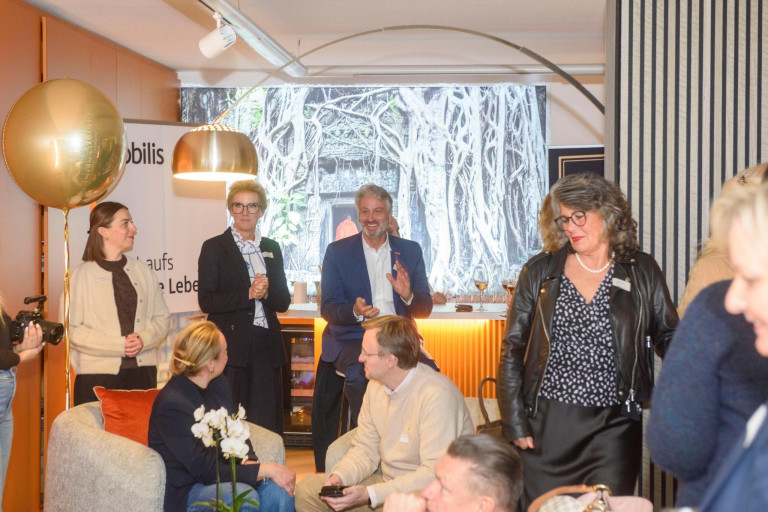 Business-Event mit mehreren Personen in einem modernen Raum, Networking und Gespräche am Stehtisch