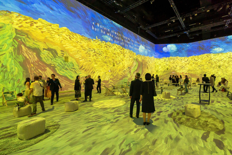 Immersive Vincent van Gogh Ausstellung mit Projektionen seiner Kunstwerke Besucher in einer immersiven Vincent van Gogh Ausstellung mit Projektionen seiner berühmten Gemälde