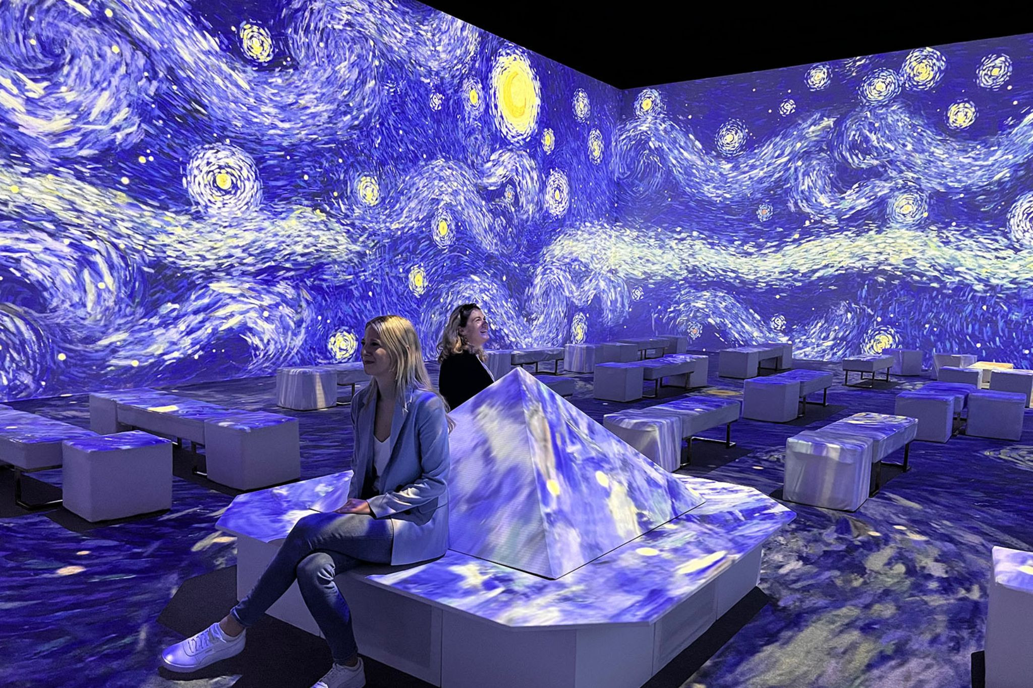 Van Gogh Ausstellung: Immersive Projektion von Sternennacht mit Besuchern Van Gogh Ausstellung mit immersiver Projektion von Sternennacht und Besuchern