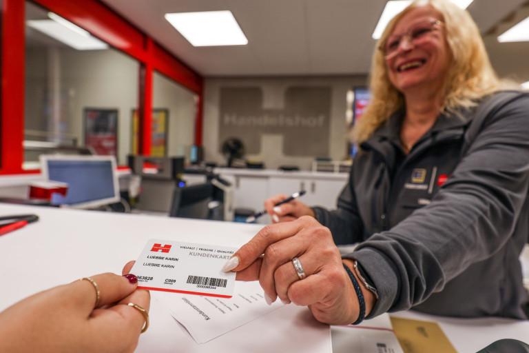 Handelshof Kundenkarte wird an Kundin am Empfang übergeben