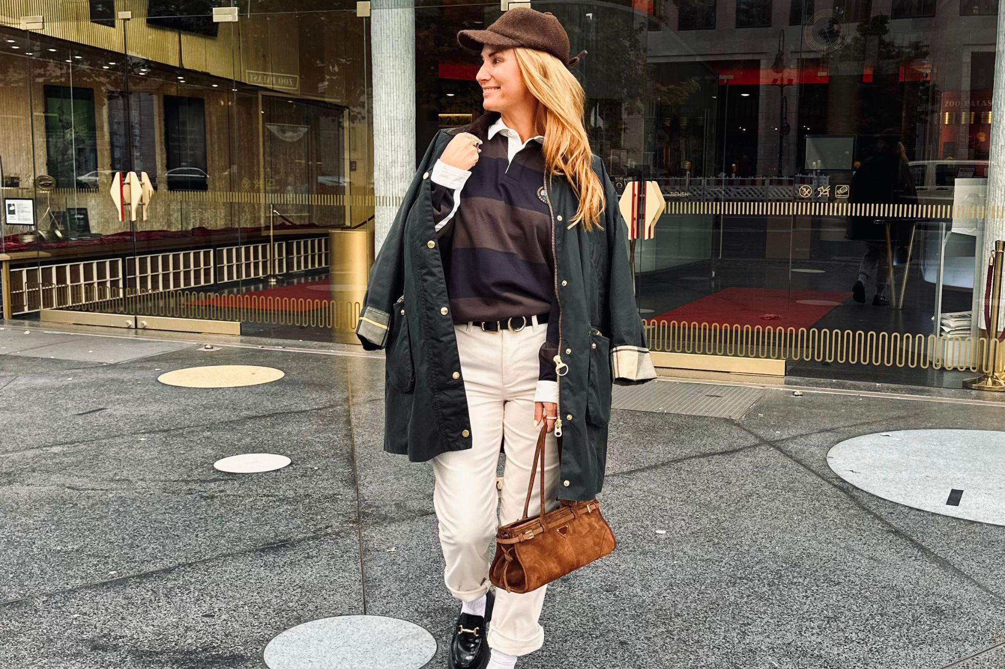 Stilkolumne: Trendiges Streetstyle-Outfit mit Mantel, Rugbyshirt und Handtasche Modisches Streetstyle-Outfit für die Stilkolumne: Frau mit schwarzem Mantel, gestreiftem Rugbyshirt, heller Hose und brauner Handtasche