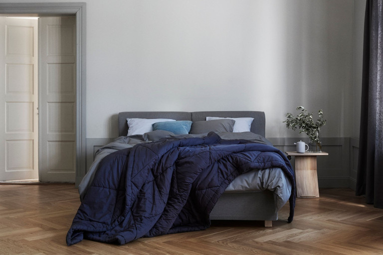 Fennobed Boxspringbett in modernem Schlafzimmer mit blauer Decke