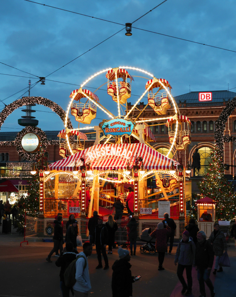Circus Roncalli Riesenrad auf dem Weihnachtsmarkt vor dem Bahnhof bei Abendstimmung Circus Roncalli Riesenrad auf einem festlich beleuchteten Weihnachtsmarkt vor dem Bahnhof