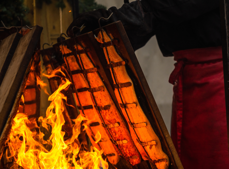 Flammlachs am offenen Feuer auf dem finnischen Weihnachtsmarkt genießen Traditionelles Flammlachs-Grillen am offenen Feuer auf einem finnischen Weihnachtsmarkt