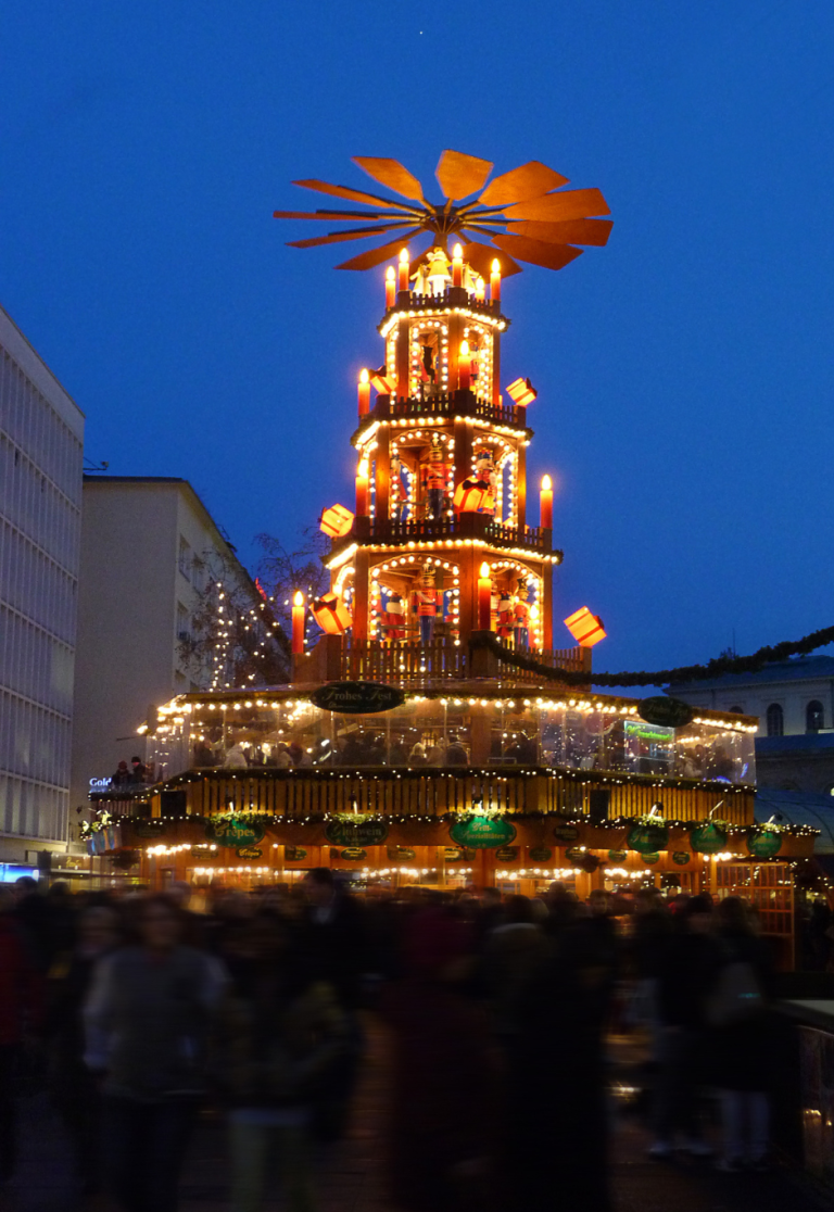 Weihnachtsmarkt am Kröpcke in Hannover mit festlich beleuchteter Weihnachtspyramide Beleuchtete Weihnachtspyramide auf dem Weihnachtsmarkt am Kröpcke in Hannover bei Abenddämmerung