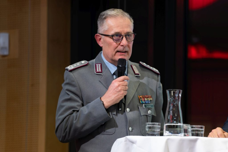 Bundeswehr-Offizier in Uniform spricht bei Veranstaltung am Rednerpult mit Mikrofon
