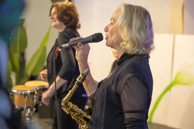 Sängerin mit Saxophon und Mikrofon auf der Bühne – Kloepperfotodesign Sängerin mit Saxophon und Mikrofon bei Live-Auftritt, aufgenommen von Kloepperfotodesign