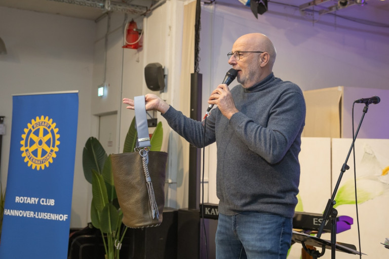 Präsentation einer Ledertasche auf Event – aufgenommen von Kloepperfotodesign Person präsentiert Ledertasche auf einer Veranstaltung – Foto von Kloepperfotodesign