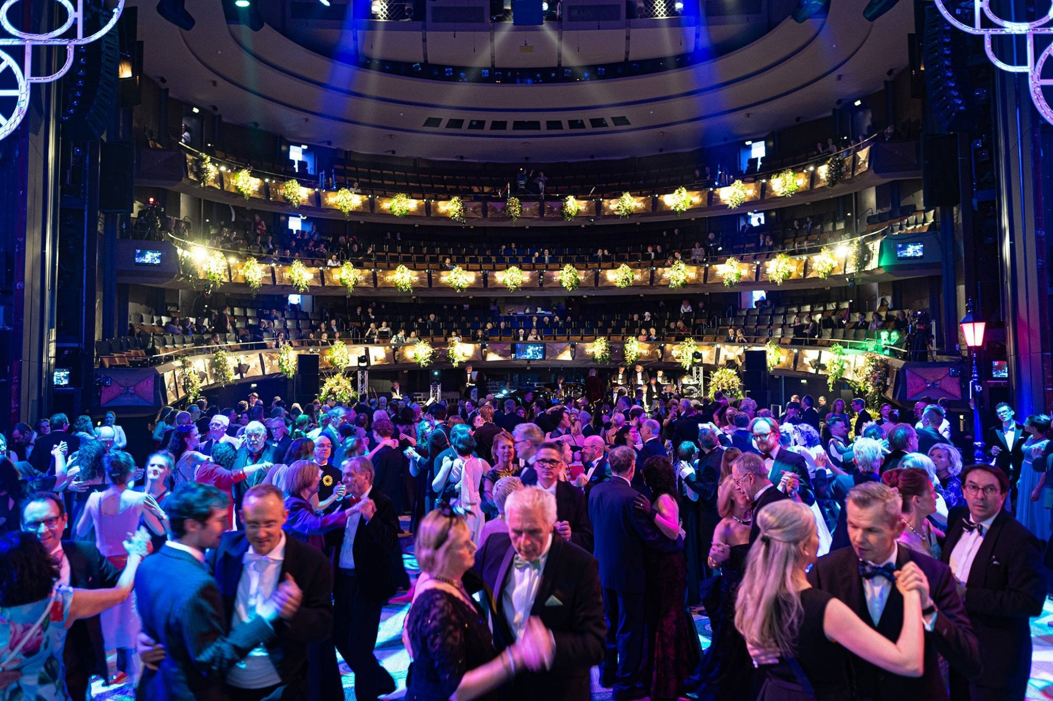 Tanzende Gäste auf einem festlichen Ball in einem prunkvoll geschmückten Veranstaltungssaal