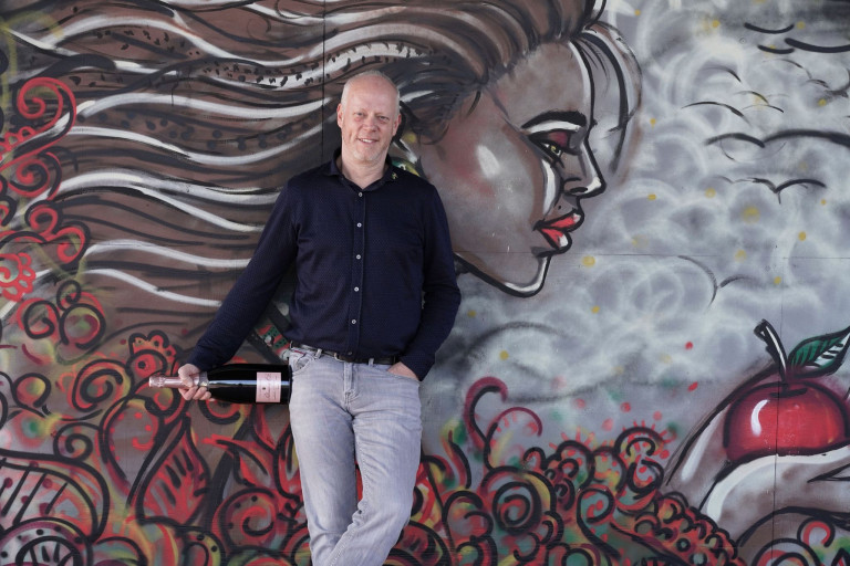 Mann mit Sektflasche vor Graffiti-Wand an Silvester Mann mit Sektflasche vor Graffiti-Wand an Silvester