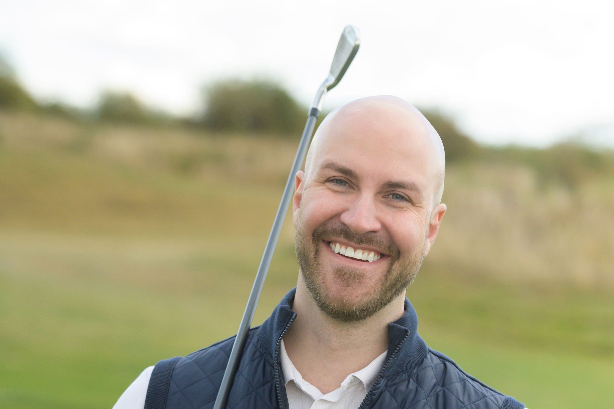 Mann mit Golfschläger auf dem Golfplatz beim Golfen
