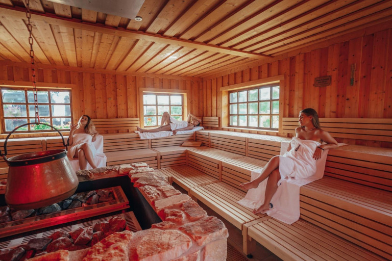 Innenansicht der Sauna in der Kristall Therme mit entspannenden Gästen auf Holzbänken