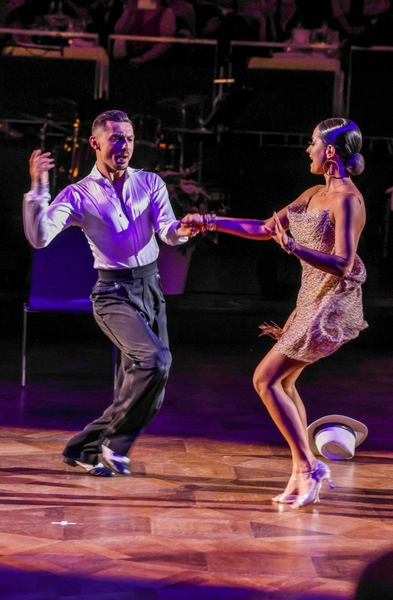 Tanzpaar beim Winter Ball auf der Tanzfläche, elegante Abendgarderobe und festliche Atmosphäre