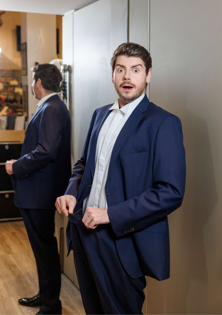 Rene Oliver im blauen Anzug vor dem Spiegel Rene Oliver trägt einen eleganten blauen Anzug und steht vor einem Spiegel