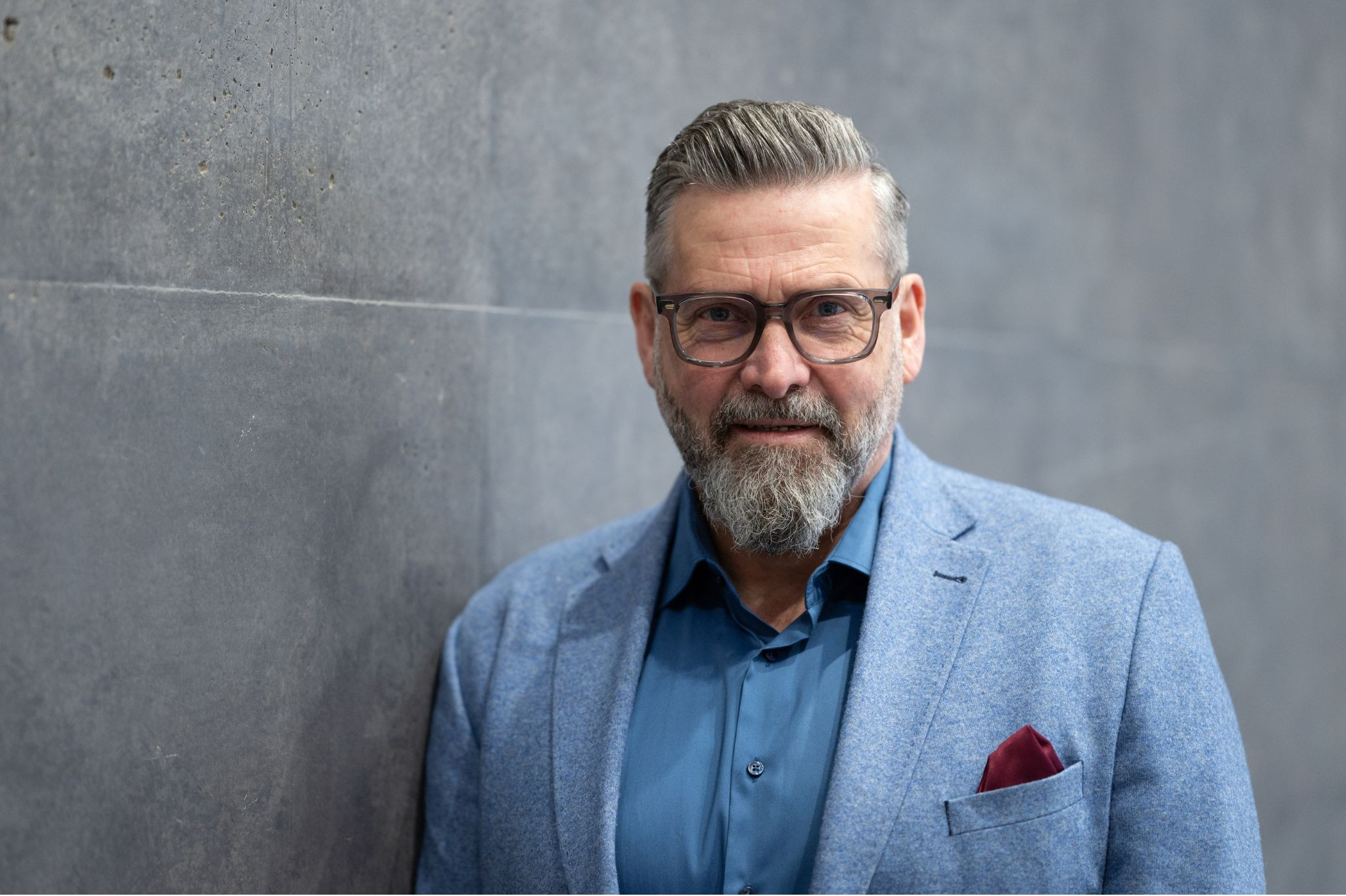 Geschäftsmann im modernen Anzug vor Betonwand bei Digitales Hannover