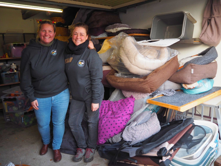 Tafel für Tiere Hannover – Spendenlager mit Tierbetten und Zubehör Mitarbeiterinnen der Tafel für Tiere Hannover vor gespendeten Tierbetten und Zubehör