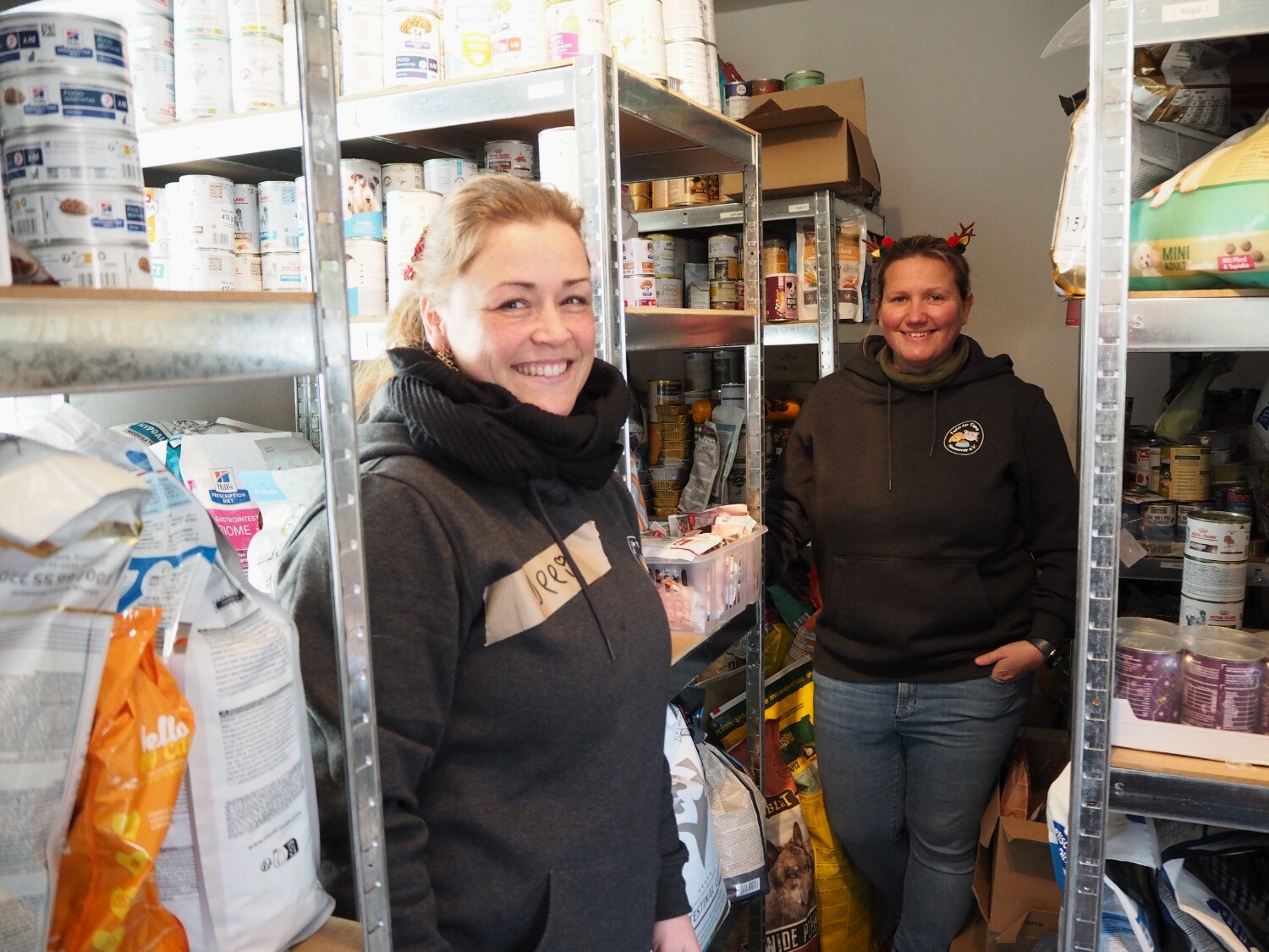 Lagerraum der Tafel für Tiere Hannover mit Tierfutter und zwei Mitarbeitenden