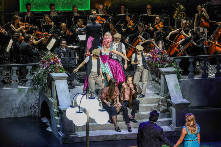 Opernball: Bühnenaufführung mit Orchester und Künstlern in historischen Kostümen Bühnenaufführung mit Orchester beim Opernball, Künstler in historischen Kostümen auf einer Treppe