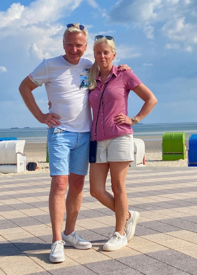 Paar am Strand mit Strandkörben, beliebtes Reiseziel am Meer