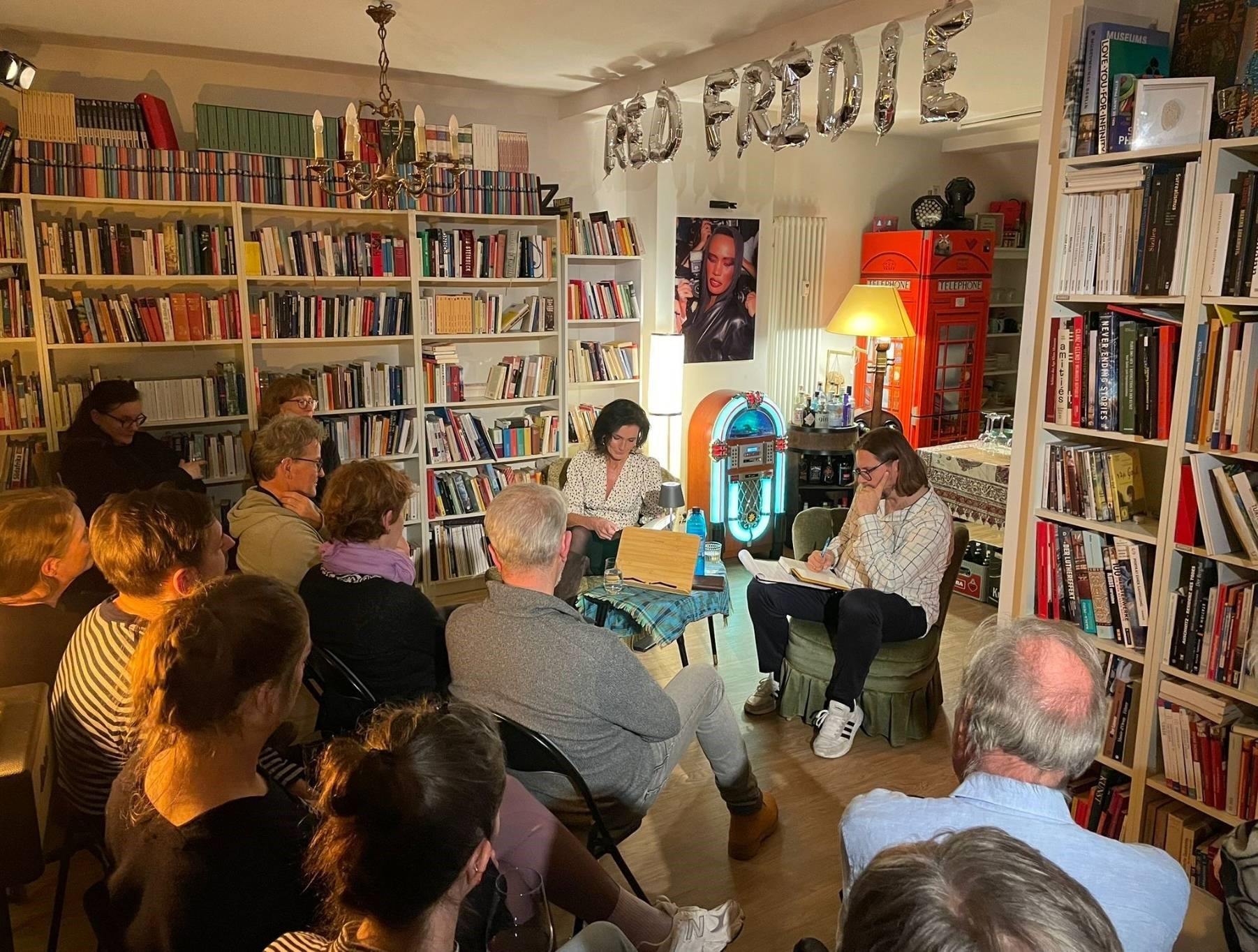 Lesung in einer Bibliothek mit Red Fridge Dekoration, Jukebox und britischer Telefonzelle