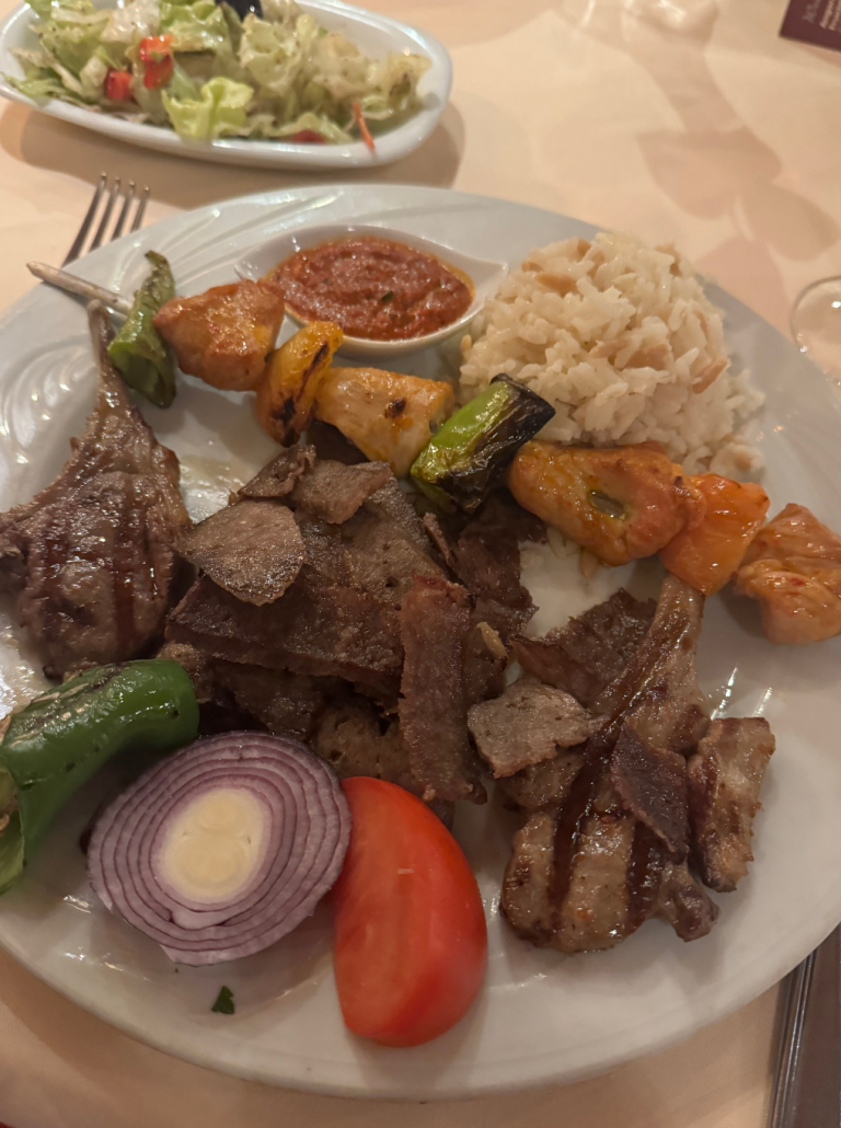 Teller mit gemischtem Grillfleisch, Reis, gegrilltem Gemüse und Soße – typisch türkische Spezialität