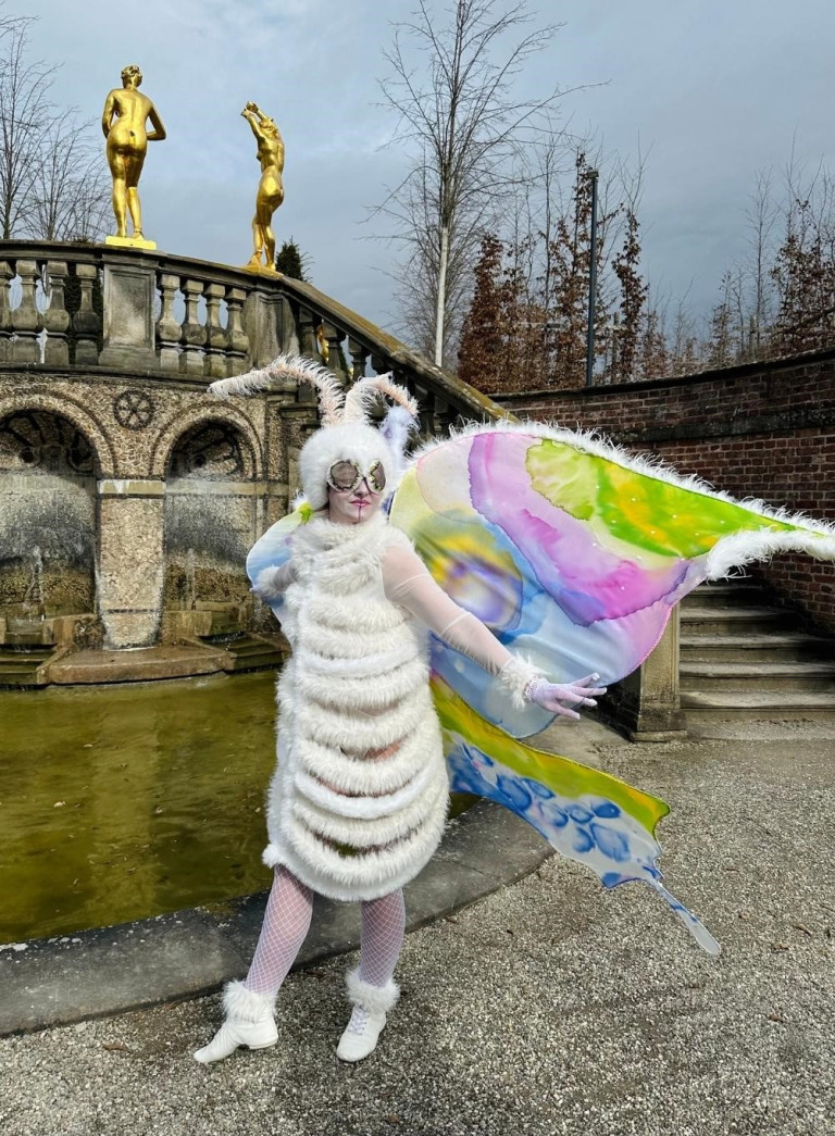 Künstler im fantasievollen Schmetterlingskostüm beim Kleines Fest 2026 vor Brunnenkulisse