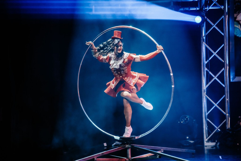 GOP Varieté-Theater: Artistin mit Cyr Wheel in rotem Kostüm auf der Bühne Artistin in rotem Kostüm bei einer Cyr Wheel Akrobatik-Show auf der Bühne im GOP Varieté-Theater