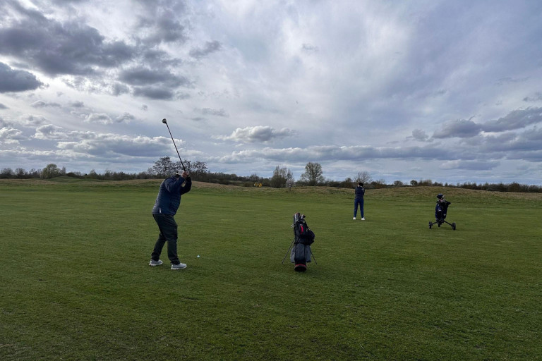 Golfer auf dem Fairway beim Abschlag unter bewölktem Himmel – grasgefluester-2