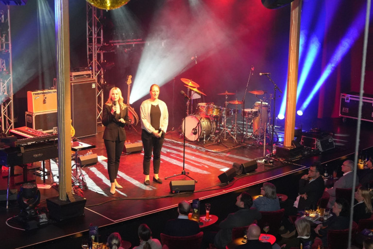 Konzert im Jazz Club GOP – Live-Auftritt mit Moderatorinnen und Publikum Bühne beim Konzert im Jazz Club GOP mit zwei Moderatorinnen und Musik-Equipment, Publikum im Vordergrund