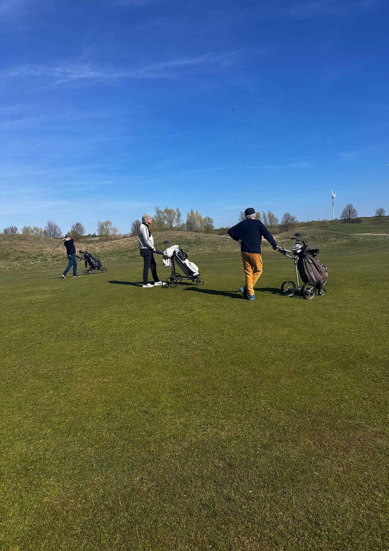 Grasgeflüster: Drei Golfer auf dem Golfplatz bei sonnigem Wetter