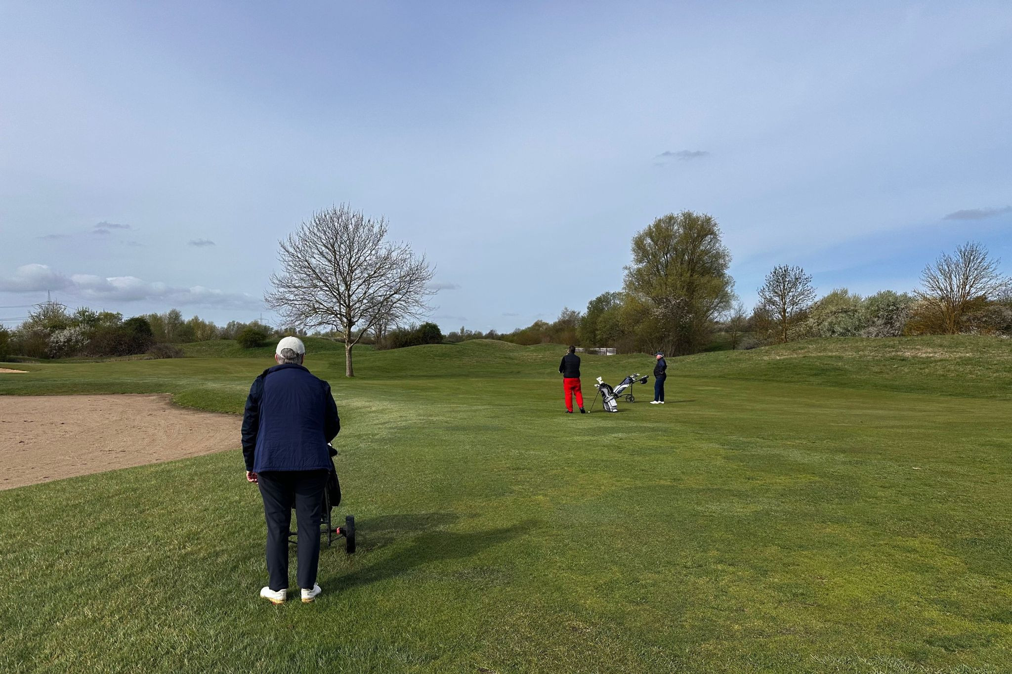Golfspieler auf dem Fairway bei Grasgeflüster, Golfrunde im Grünen