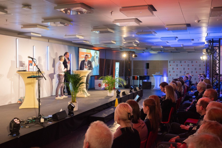 Podiumsdiskussion bei einer hannoverimpuls Veranstaltung mit Publikum und Rednern auf der Bühne