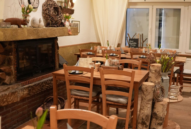 Gemütliches Restaurant mit Holztischen und Kamin – artikel koch 10
