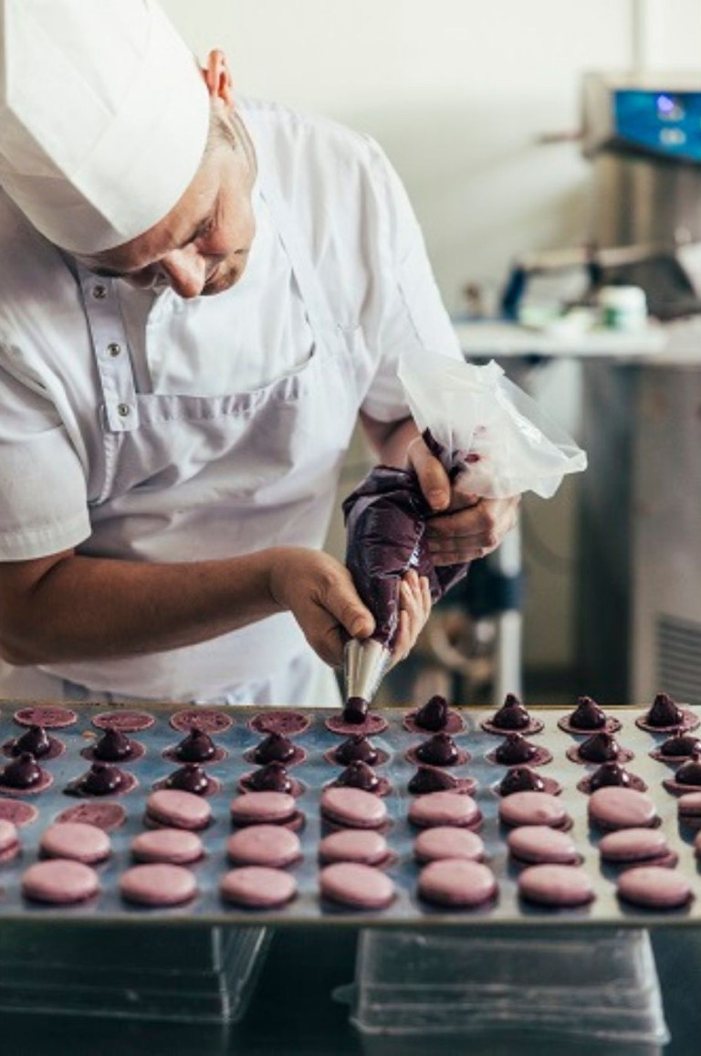 Konditor füllt Macarons in einer professionellen Bäckerei – bilder nobilis web