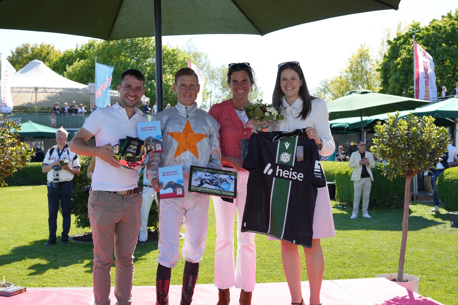 Siegerehrung beim Hannoverschen Rennverein mit Jockey, Blumenstrauß und Hannover 96 Trikot