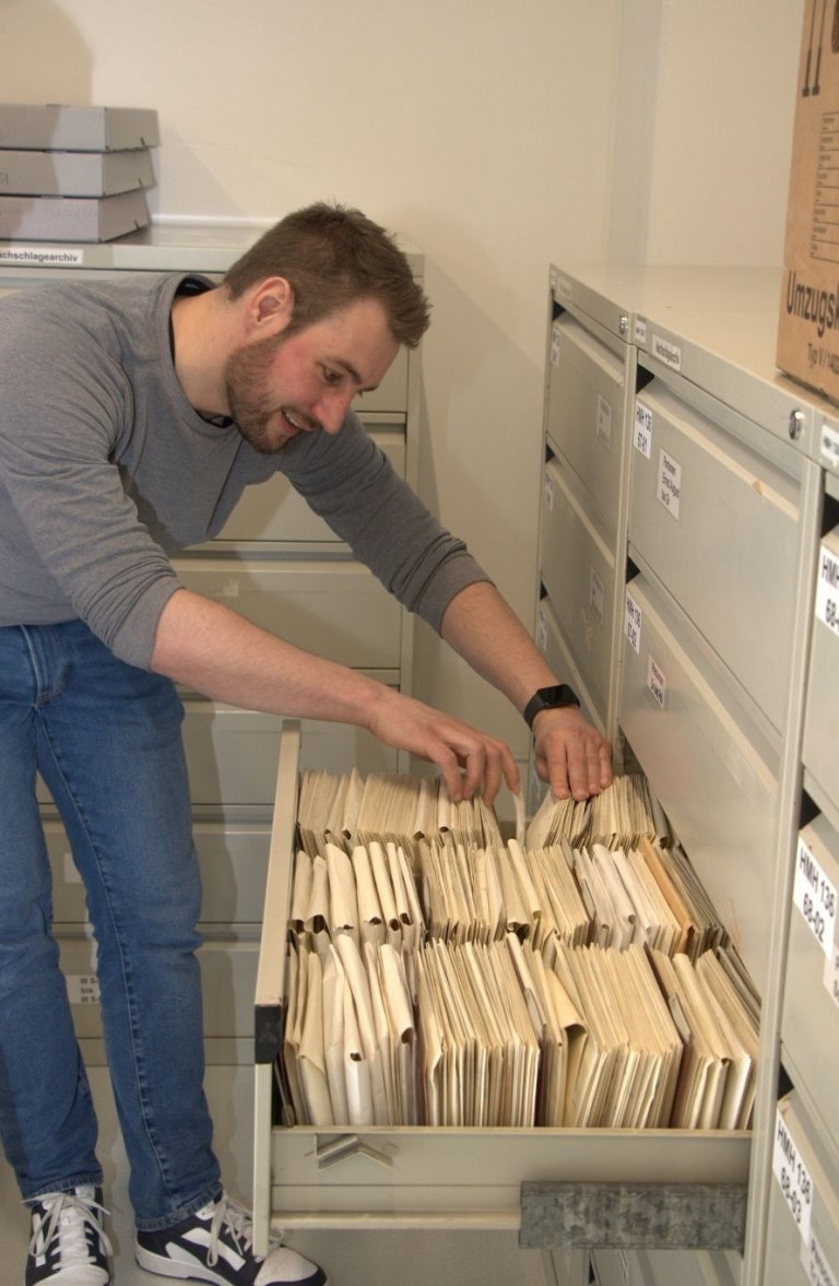 Person durchsucht Akten in einem Archivschrank – bilder nobilis web