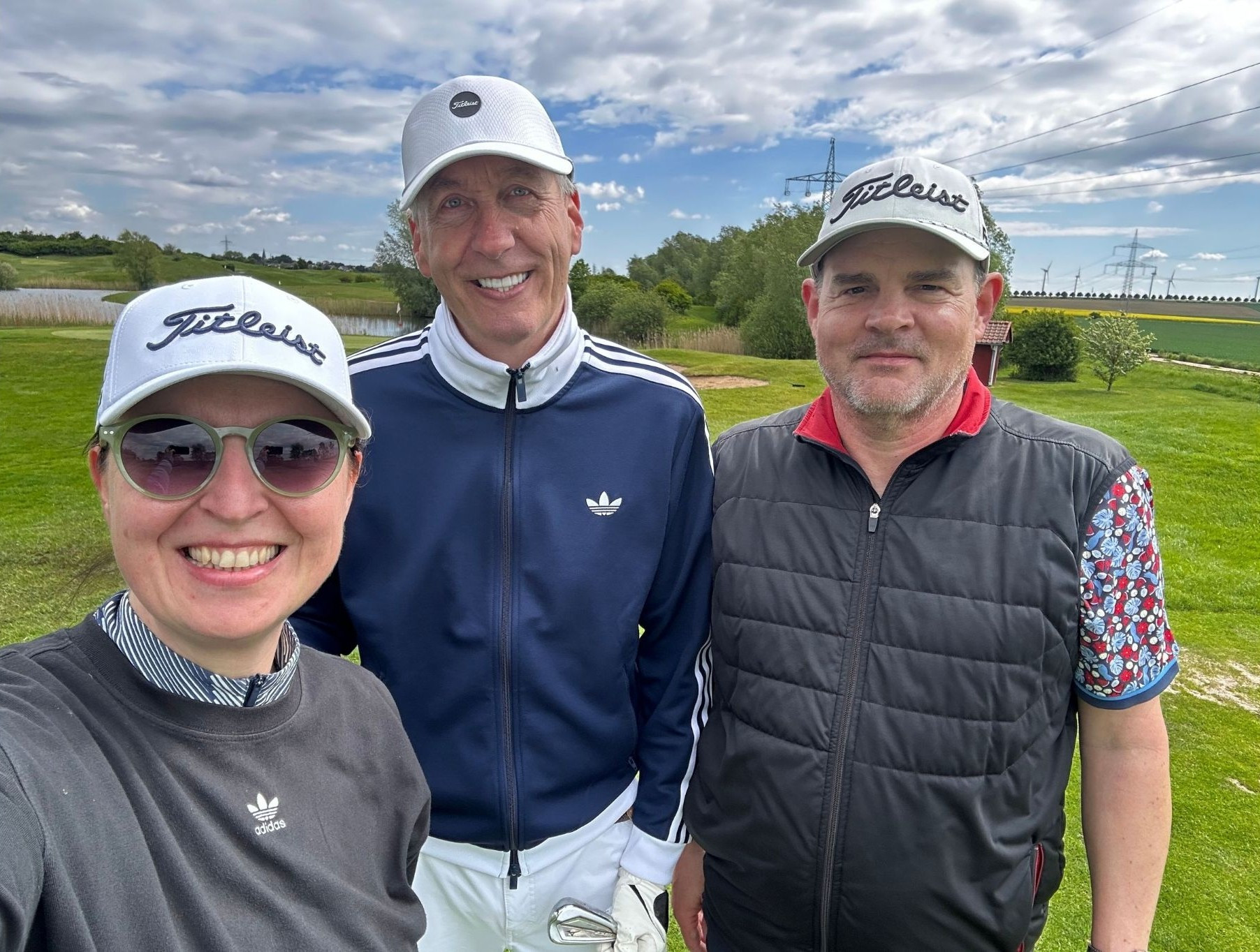 Drei Personen beim Golfspielen auf einer grünen Wiese, Bild für nobilis Webauftritt