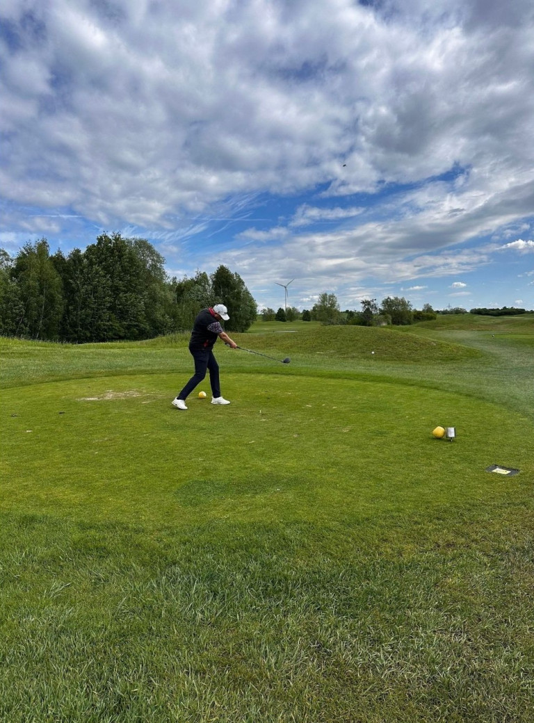 Golfer beim Abschlag auf dem Golfplatz Nobilis unter blauem Himmel
