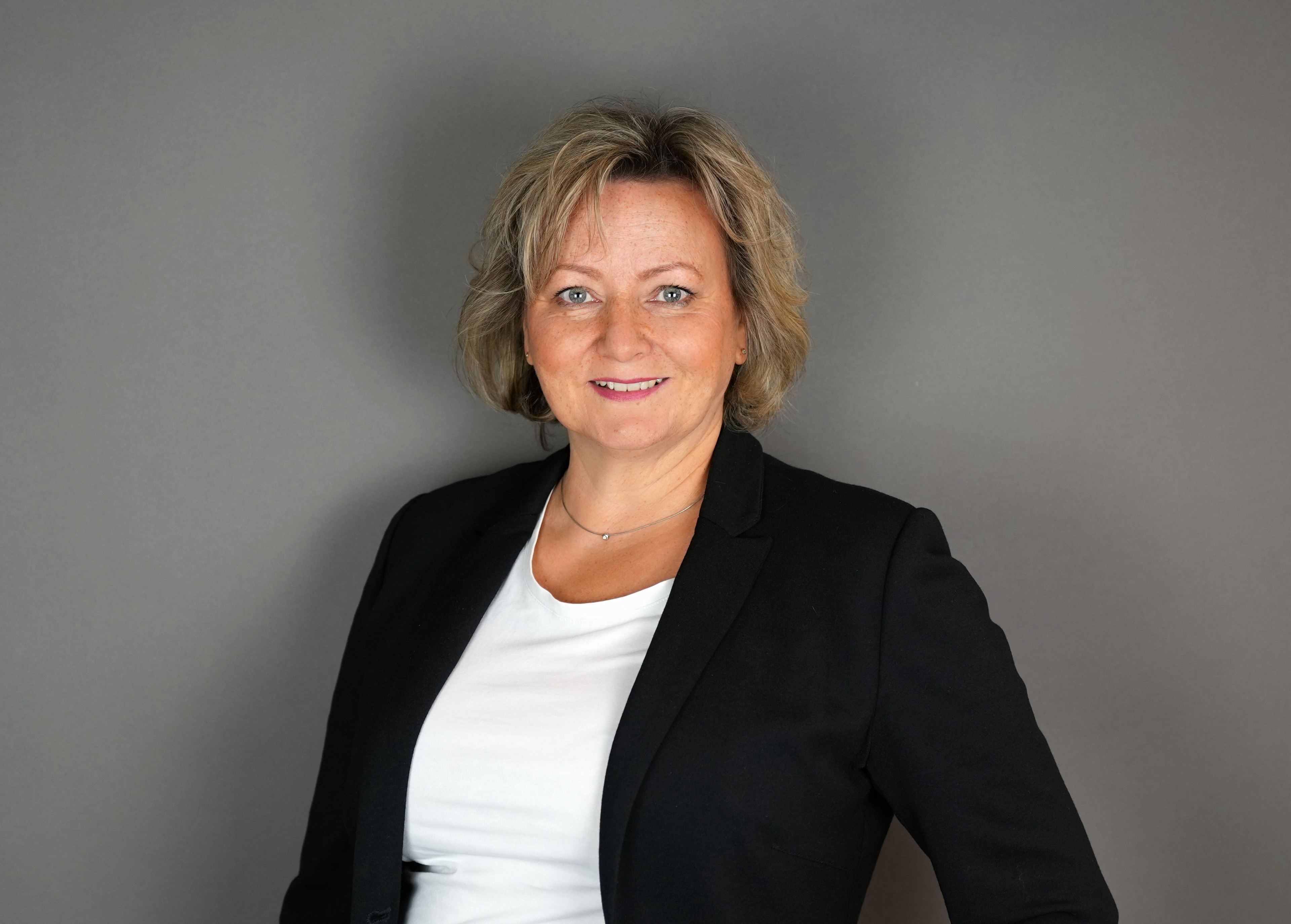 Porträt von Sabine Neumann im Editorial-Stil, Frau mit blondem Haar und schwarzem Blazer