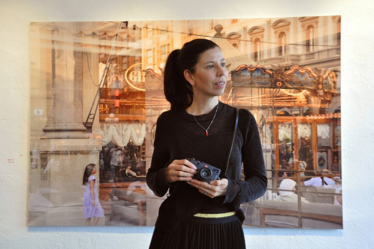 Franziska Stunkel mit Kamera vor einem Kunstwerk oder Fotografie-Ausstellung
