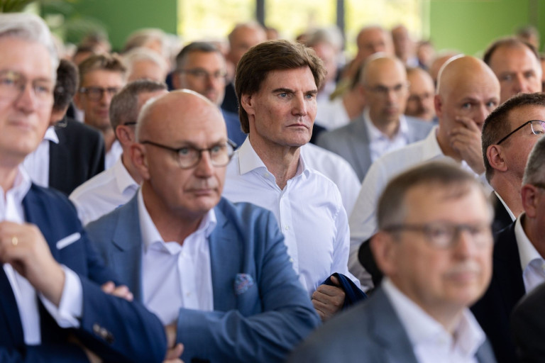 Gruppe von Menschen bei einer Veranstaltung, Fokus auf Person im weißen Hemd - jw-17