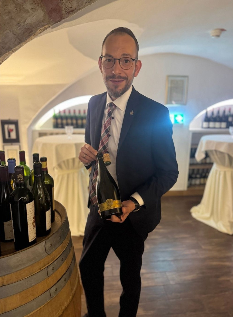 Sommelier im Weinkeller präsentiert Weinflasche – bilder-nobilis-web