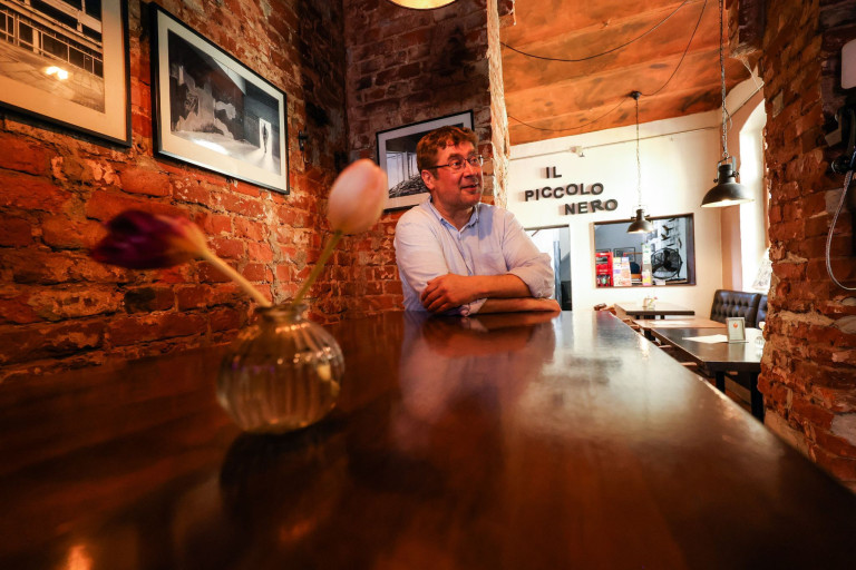 Desimo in der Bar Il Piccolo Nero – gemütliche Atmosphäre mit Backsteinwand Desimo in der Bar Il Piccolo Nero mit Backsteinwand und Blumen auf dem Tisch