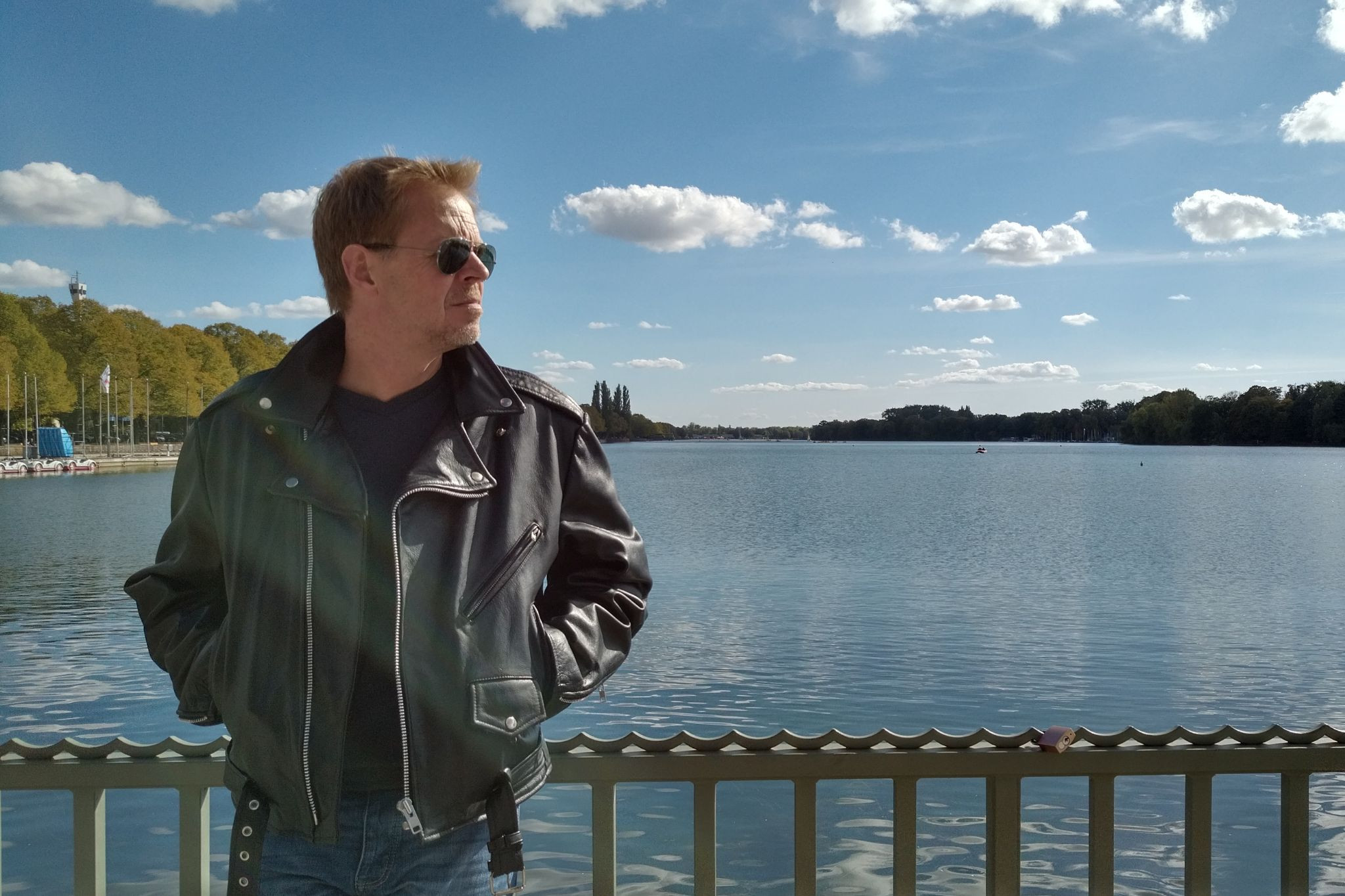 Lars Pennigsdorf mit Sonnenbrille und Lederjacke am Seeufer bei sonnigem Wetter
