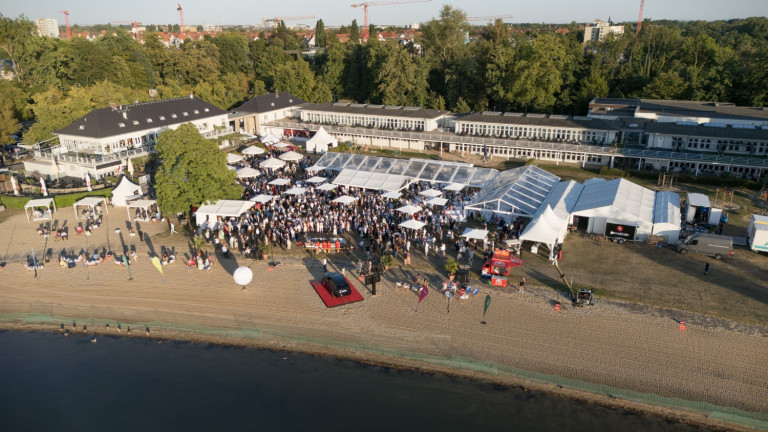 UVN Sommerfest 2026 – Veranstaltung am Strand mit Gästen und Festzelten Luftaufnahme vom UVN Sommerfest 2026 am Strand mit vielen Gästen und Festzelten