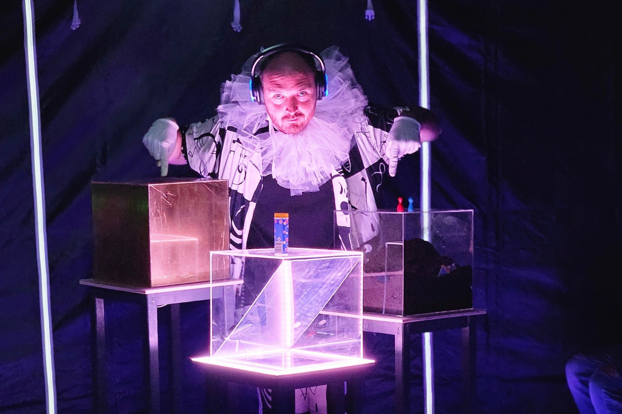 Performer im Theaterlabor mit futuristischer Beleuchtung und Kostüm, experimentelle Theaterkunstszene