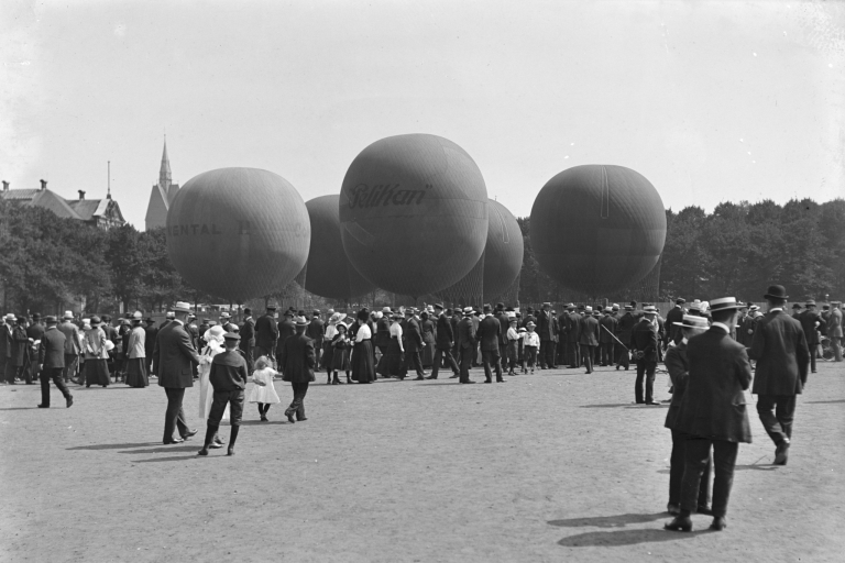 Historisches Schwarzweiß-Foto von Menschenmenge bei Ballonstart mit Pelikan-Ballon, Anfang 20. Jahrhundert